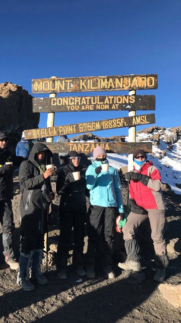 Climbers celebrating at the summit of Mount Kilimanjaro