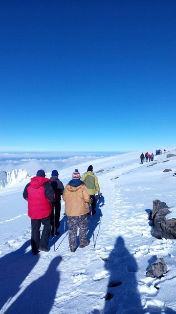 Climbers walking across the glacier near Uhuru Peak